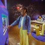 child standing in front of exhibit at Uniquely Us